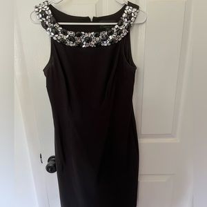 Knee length form fitting dress with detail on neckline